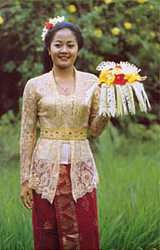 Yanni in traditional dress with one of the intricate offerings for a religios festival